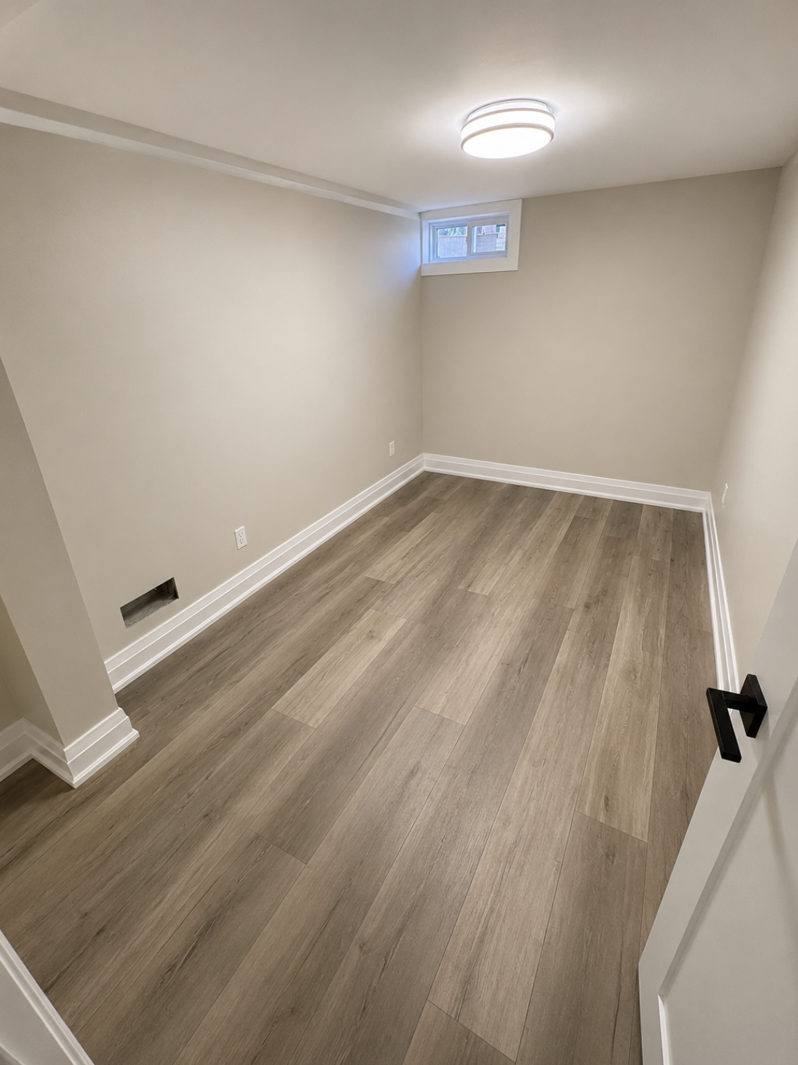 Finished basement room with vinyl plank flooring